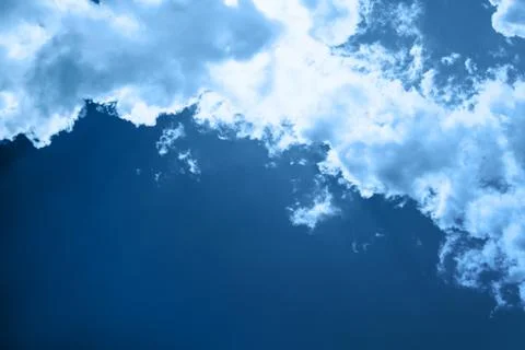 White fluffy clouds in a bright blue sky on a sunny day. Stock Photos