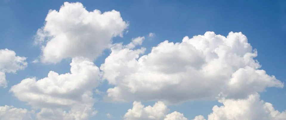 White fluffy clouds in deep blue sky Stock Photos