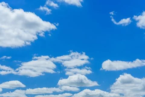White fluffy clouds in deep blue sky Stock Photos