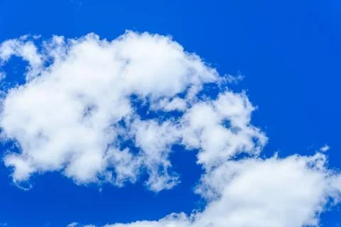 White fluffy clouds in a deep blue sky Stock Photos
