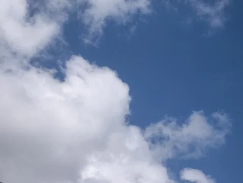 White fluffy clouds in the deep blue sky background Stock Photos