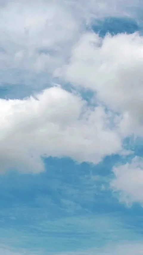 White fluffy clouds drifting slowly across a bright blue summer sky background Stock Footage 342572748