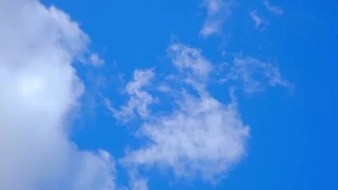 White fluffy clouds float in a bright blue sky during a clear day. cumulus Stock Footage 343781327