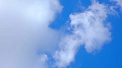 White fluffy clouds float in a bright blue sky during a clear day. cumulus Stock Footage 343781355