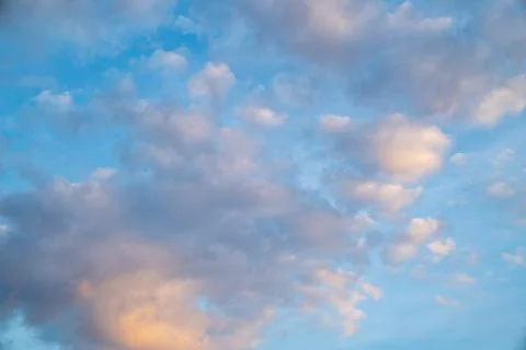 White fluffy clouds float gently in a clear blue sky on a bright sunny day... Stock Photos