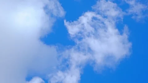 White fluffy clouds floating in a clear blue sky. Natural background, weather Stock Footage 341854606