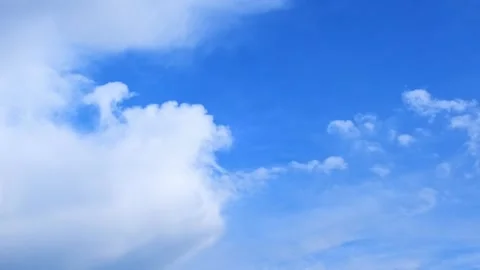 White fluffy clouds floating in a clear blue sky. Natural background, weather Stock Footage 343573822