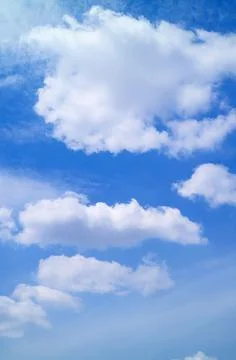 White Fluffy Clouds Floating on Vibrant Blue Sky Stock Photos