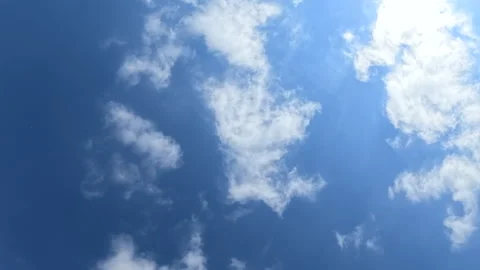 White fluffy clouds forming a heart shape in a vibrant blue sky with a faint Stock-Footage 342886784