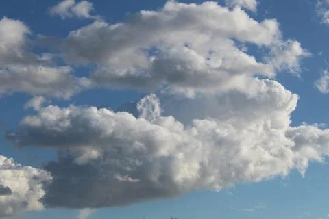 White fluffy clouds in a light blue sky. Clear weather Stock Photos
