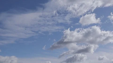 White fluffy clouds move quickly against the blue sky. Stock Footage 262525812