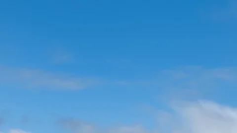 White fluffy clouds moving right to left against blue sky time lapse Stock Footage 128621546