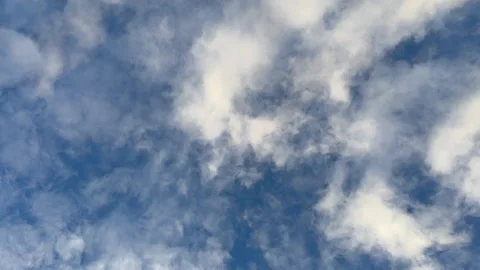 White fluffy clouds moving slowly across a blue sky Stock Footage 330591918