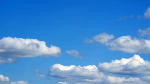 White fluffy clouds over blue sky on sunny day Foto stock