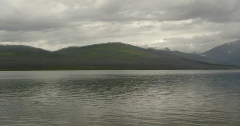 White fluffy clouds over mountains and lake Stock Footage 97607944