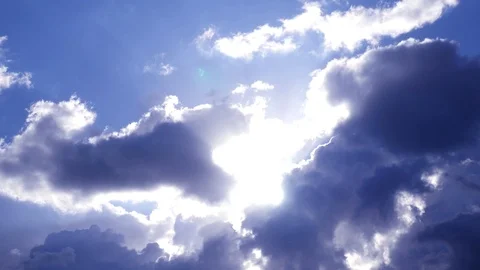 White fluffy clouds in the rays of the sun in the blue sky. 4k, 3840x2160, HD Stock Footage 97430357