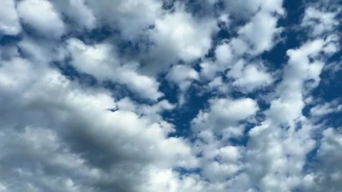 White fluffy clouds scattered across a deep blue sky Vídeos de archivo 338201395