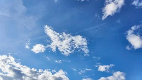 White fluffy clouds in the sky. Blue sky and cloud cover on a sunny summer da Stock Photos
