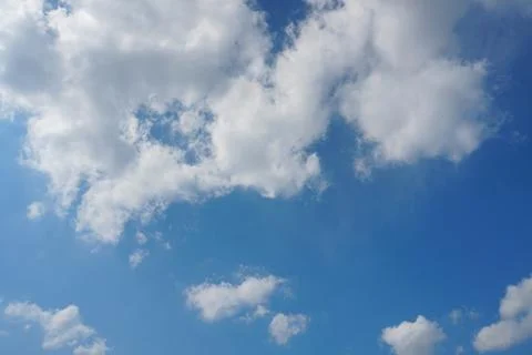 White fluffy clouds in the sky. Blue sky and cloud cover on a sunny summer da Stock Photos