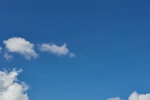 White fluffy clouds in the sky. Blue sky and cloud cover on a sunny summer da Stock Photos