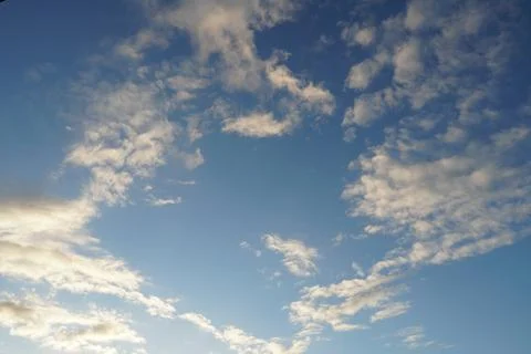 White fluffy clouds in the sky. Blue sky and cloud cover on a sunny summer da Stock Photos