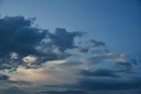 White fluffy clouds in the sky. Blue sky and cloud cover on a sunny summer da Stock Photos
