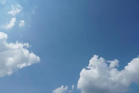 White fluffy clouds in the sky. Blue sky and cloud cover on a sunny summer da Stock Photos