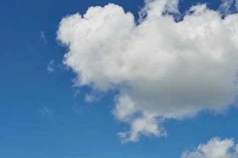 White fluffy clouds in the sky. Blue sky and cloud cover on a sunny summer da Stock Photos