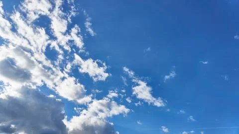 White fluffy clouds in the sky. Blue sky and cloud cover on a sunny summer da Stock Photos