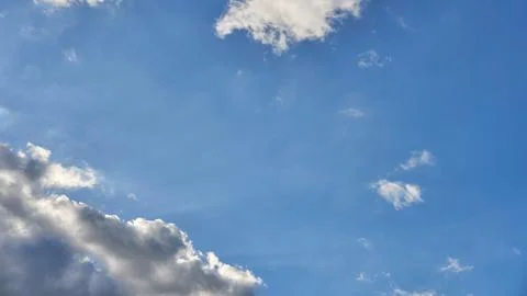 White fluffy clouds in the sky. Blue sky and cloud cover on a sunny summer da Stock Photos