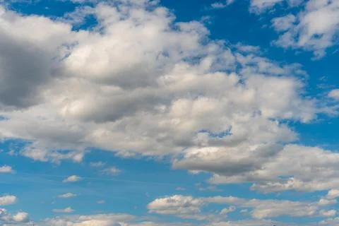 White fluffy clouds in the sky. Blue sky and cloud cover on a sunny summer da Stock Photos