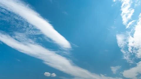 White fluffy clouds in the sky. Blue sky and cloud cover on a sunny summer da Stock Photos