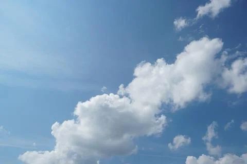 White fluffy clouds in the sky. Blue sky and cloud cover on a sunny summer da Stock Photos