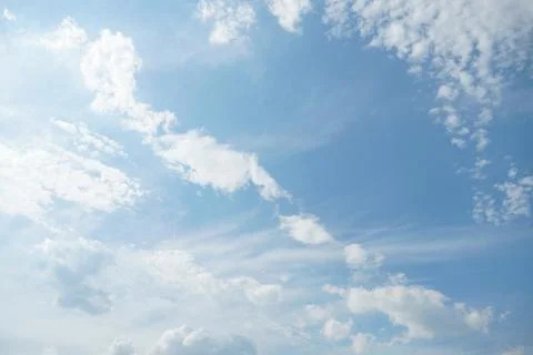 White fluffy clouds in the sky. Blue sky and cloud cover on a sunny summer .. Stock Photos