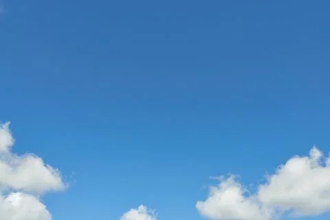 White fluffy clouds in the sky. Blue sky and cloud cover on a sunny summer da Stock Photos