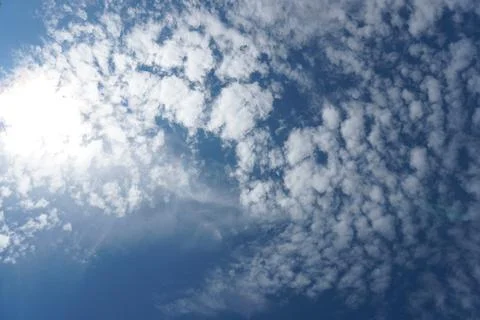 White fluffy clouds in the sky. Blue sky and cloud cover on a sunny summer da Stock Photos