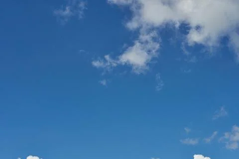 White fluffy clouds in the sky. Blue sky and cloud cover on a sunny summer da 写真素材