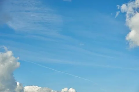 White fluffy clouds in the sky. Blue sky and cloud cover on a sunny summer da Stock Photos
