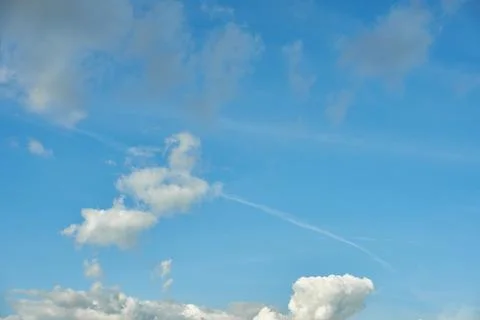 White fluffy clouds in the sky. Blue sky and cloud cover on a sunny summer da Stock Photos