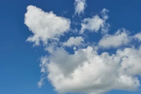 White fluffy clouds in the sky. Blue sky and cloud cover on a sunny summer da Stock Photos