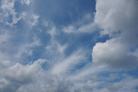White fluffy clouds in the sky. Blue sky and cloud cover on a sunny summer da Stock Photos
