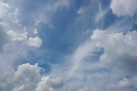 White fluffy clouds in the sky. Blue sky and cloud cover on a sunny summer da Stock Photos