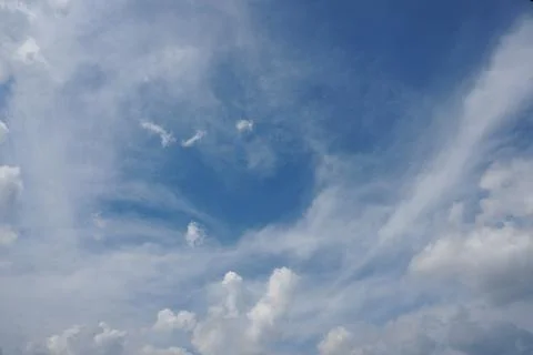 White fluffy clouds in the sky. Blue sky and cloud cover on a sunny summer da Stock Photos