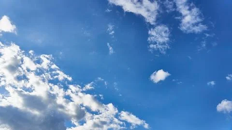 White fluffy clouds in the sky. Blue sky and cloud cover on a sunny summer da Stock Photos