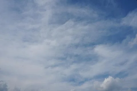 White fluffy clouds in the sky. Blue sky and cloud cover on a sunny summer da Stock Photos