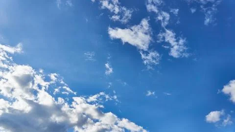 White fluffy clouds in the sky. Blue sky and cloud cover on a sunny summer da Stock Photos