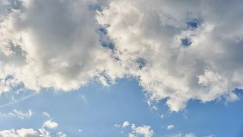 White fluffy clouds in the sky. Blue sky and cloud cover on a sunny summer da Stock Photos