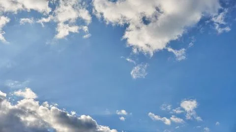 White fluffy clouds in the sky. Blue sky and cloud cover on a sunny summer da Stock Photos