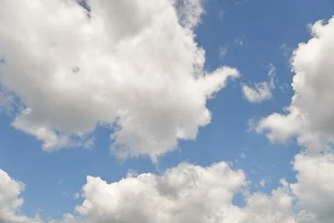 White fluffy clouds in the sky. Blue sky and cloud cover on a sunny summer da Stock Photos