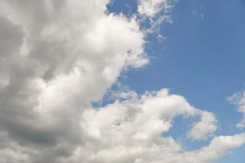 White fluffy clouds in the sky. Blue sky and cloud cover on a sunny summer da Stock Photos